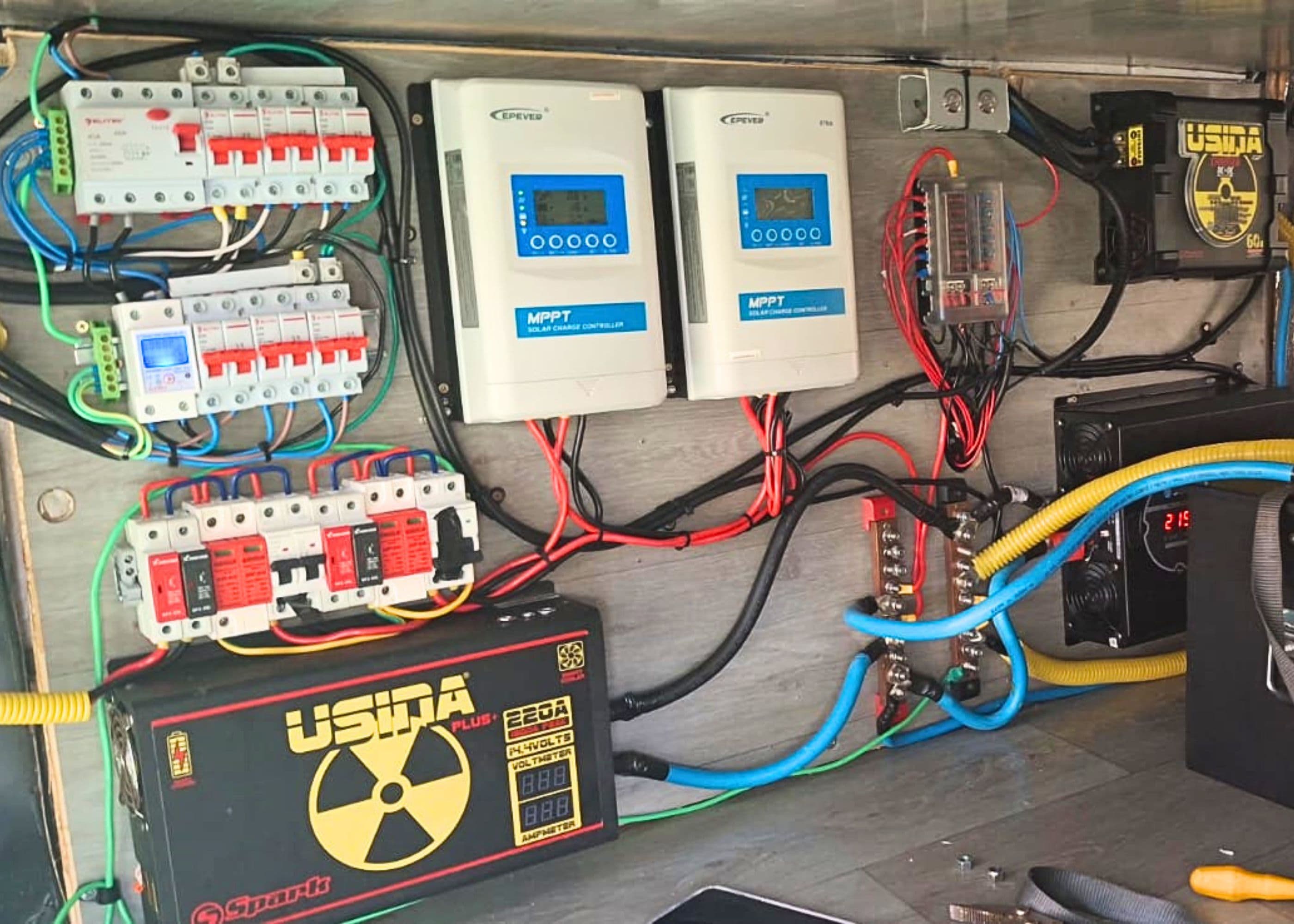 Painel elétrico completo instalado no motorhome, com controladores MPPT, disjuntores, barramentos e bateria
